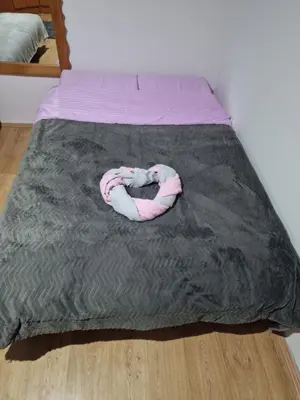 a pink and white snake laying on a bed at Jasemin in Ćuprija