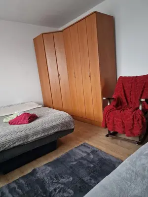 a bedroom with a bed and a chair and a cabinet at Jasemin in Ćuprija