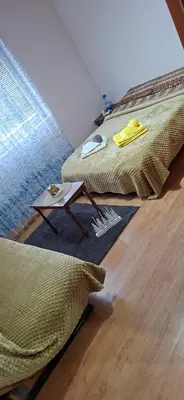 a bedroom with two beds and a table on the floor at Jasemin in Ćuprija