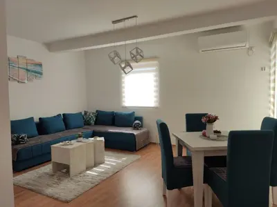 a living room with a blue couch and a table at Apartman Magnolija in Vrnjačka Banja