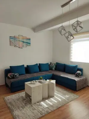 a living room with a blue couch and a table at Apartman Magnolija in Vrnjačka Banja
