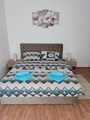 a bedroom with a bed with blue pillows on it at Apartman Magnolija in Vrnjačka Banja