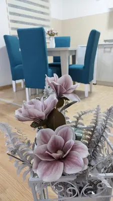 a vase with pink flowers sitting on a table at Apartman Magnolija in Vrnjačka Banja