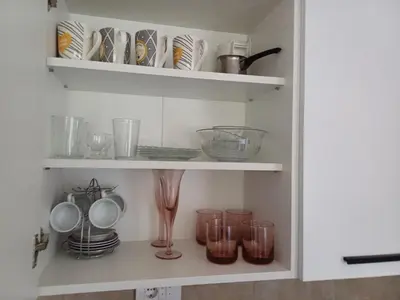 a cupboard filled with dishes and bowls and glasses at Natura Lux & Parking Free - Green Hill, blizu Akva parka in Soko Banja
