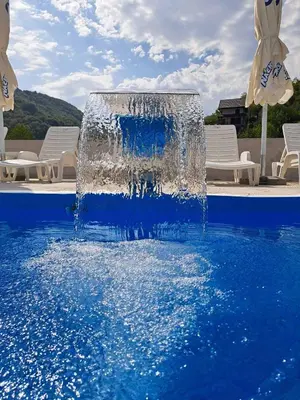 a water fountain in the middle of a swimming pool at Apartmani Sunce Stara planina in Crni Vrh