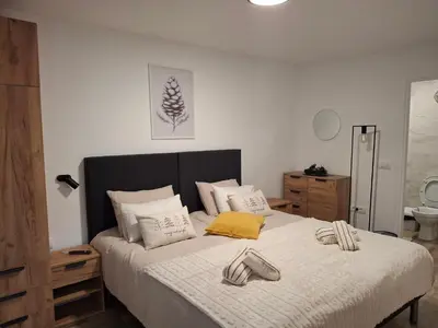 a bedroom with a bed with two shoes on it at Apartmani Sunce Stara planina in Crni Vrh