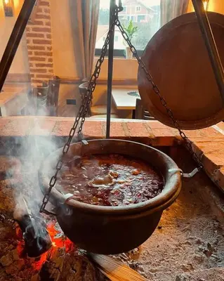 a pot of food is cooking on a fire at Apartmani Sunce Stara planina in Crni Vrh