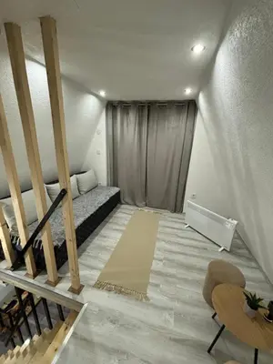 a small room with a bed and a staircase at Planinska vila KTM Lisine in Despotovac