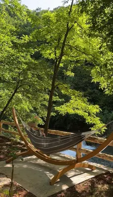 a hammock sitting next to a tree in a park at Planinska vila KTM Lisine in Despotovac