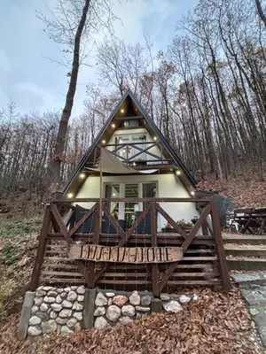 a tiny house on the side of a forest at Planinska vila KTM Lisine in Despotovac