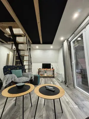 a living room with two tables and a couch at Planinska vila KTM Lisine in Despotovac