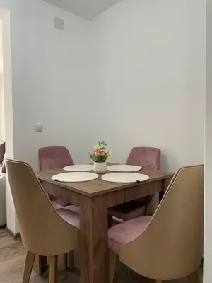 a wooden table with chairs around it with a vase on it at Apartmani Vrla NEW in Vladičin Han