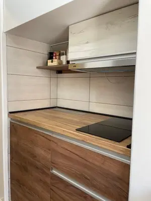 a kitchen with wooden cabinets and a stove at Apartmani Vrla NEW in Vladičin Han
