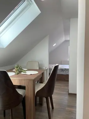 a dining room with a wooden table and chairs at Apartmani Vrla NEW in Vladičin Han