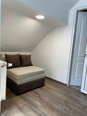a couch sitting in a room next to a door at Apartmani Vrla NEW in Vladičin Han
