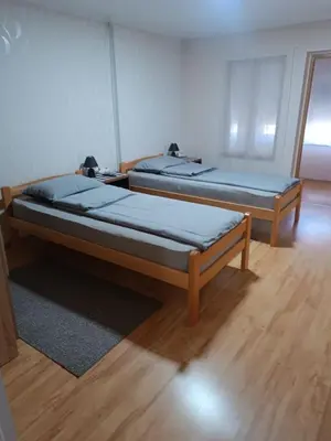 two beds in a room with wooden floors at APARTMAN Buba in Pirot