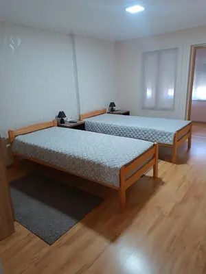 two beds in a room with wooden floors at APARTMAN Buba in Pirot