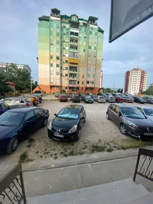 a parking lot with cars parked in front of a building at Vito Apartman - Free Parking in Vranje