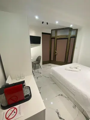 a hotel room with a bed and a red suitcase at Vito Apartman - Free Parking in Vranje