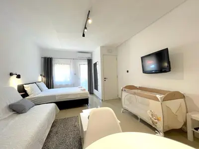 a room with two beds and a tv on the wall at LAGUNA Apartments in Vranje