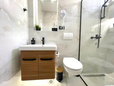 a bathroom with a toilet and a sink and a shower at LAGUNA Apartments in Vranje