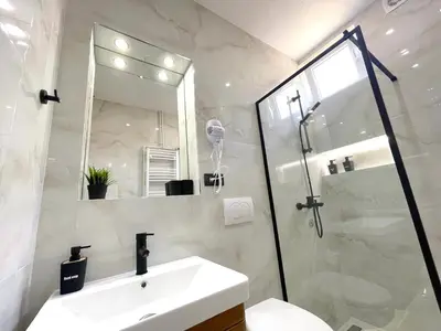 a bathroom with a sink and a shower with a mirror at LAGUNA Apartments in Vranje