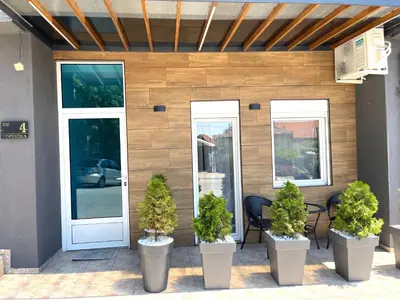 a building with three potted plants on a patio at LAGUNA Apartments in Vranje