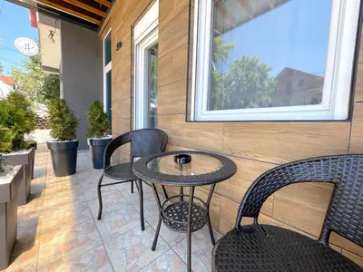 a patio with a table and chairs and a window at LAGUNA Apartments in Vranje