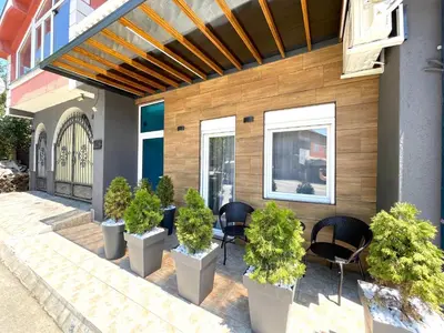 a patio with chairs and potted plants in front of a building at LAGUNA Apartments in Vranje