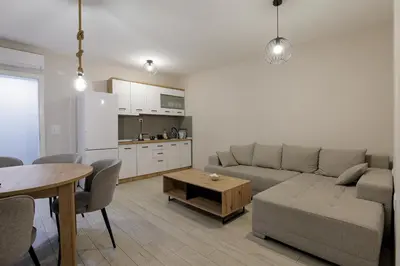 a living room with a couch and a table and a kitchen at 4-teen in Jagodina