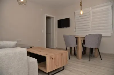 a living room with a wooden table and chairs at 4-teen in Jagodina