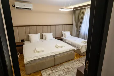 a bedroom with two beds with white pillows at Trpeza Luxury Apartments, free parking in Niš