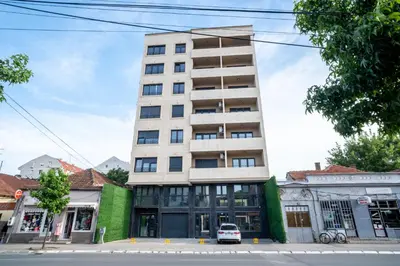 a tall building with a car parked in front of it at Trpeza Luxury Apartments, free parking in Niš