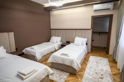 a room with two beds with white sheets at Trpeza Luxury Apartments, free parking in Niš