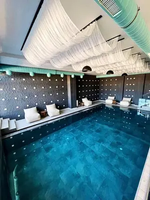 a large swimming pool in a hotel room at Milmari P87 Apartman in Cajetina