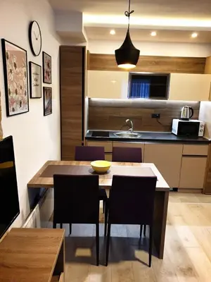 a kitchen and dining room with a table and chairs at Milmari P87 Apartman in Cajetina
