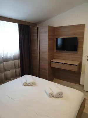 a bedroom with a bed with two towels at Milmari P87 Apartman in Cajetina
