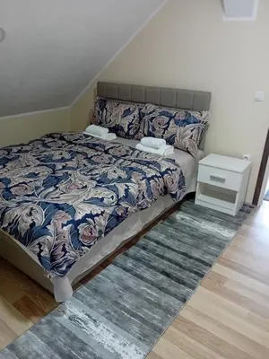 a bedroom with a bed with a blue and white comforter at Apartman Anči in Vrnjačka Banja