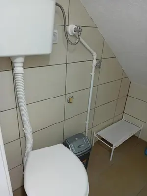 a small bathroom with a toilet and a stool at Apartman Anči in Vrnjačka Banja