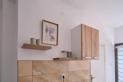 a kitchen with white walls and wooden cabinets at Studio Melem 2 in Soko Banja