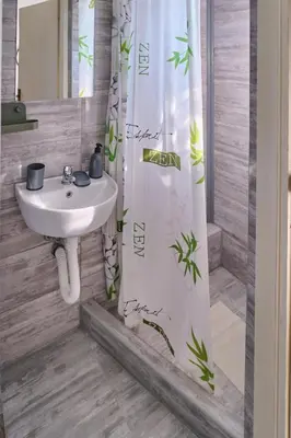a bathroom with a sink and a shower curtain at Studio Melem 2 in Soko Banja