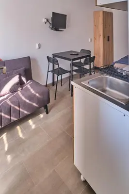 a kitchen with a couch and a sink and a table at Studio Melem 2 in Soko Banja