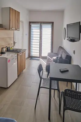 a kitchen and a living room with a table and chairs at Studio Melem 2 in Soko Banja