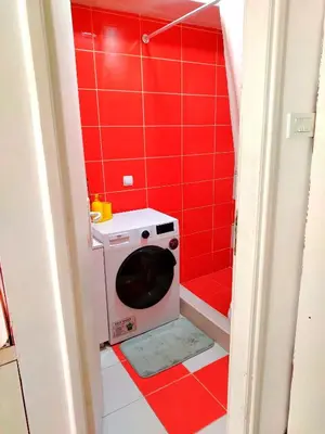a red tiled bathroom with a washing machine at City Center Sweet Apartment in Niš