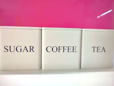 a row of books with the words sugar coffee and tea at City Center Sweet Apartment in Niš
