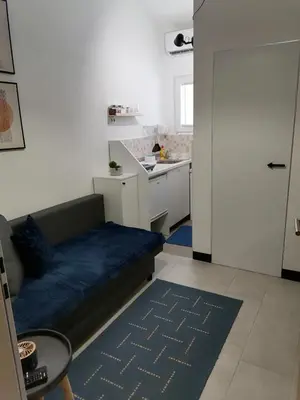a living room with a couch and a kitchen at Studio Ukras in Vrnjačka Banja