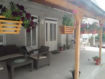 a patio with a table and chairs and potted plants at Apartman Djordjevic in Vranje