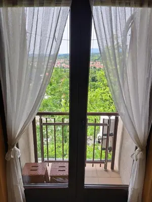 a window with curtains and a view of a balcony at Soko Banjica in Soko Banja