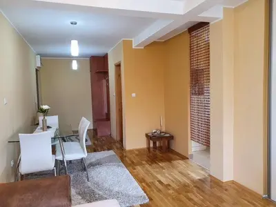 a living room with a table and white chairs at Soko Banjica in Soko Banja