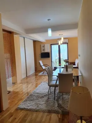 a living room with a table and a dining room at Soko Banjica in Soko Banja